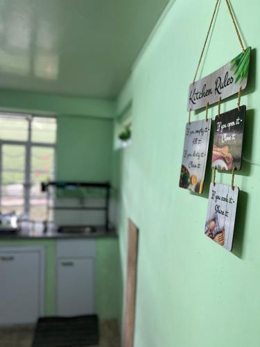 a kitchen with signs on the wall in a room at Cozy Haven 1018 Homestay in Shillong