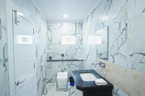 a bathroom with a sink and a marble wall at Hotel Ekta International !! 300 Mts From BABA BAIDYANATH DHAM TEMPLE !! in Deoghar