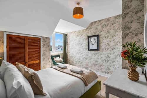 a bedroom with a bed and a table and a window at Hove Sunrise By My Getaways in Hove
