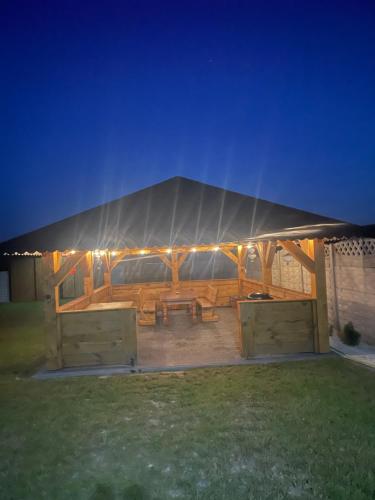 a tent with a picnic table in a yard at night at Bajkowa Chatka in Bodzentyn