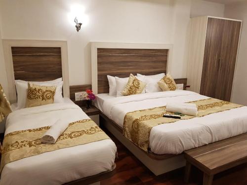 two beds in a hotel room with two bedsskirts at C P Cottage Resort in Mahabaleshwar