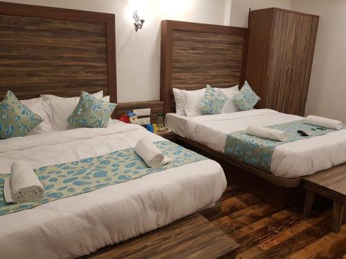a hotel room with two beds in a room at C P Cottage Resort in Mahabaleshwar