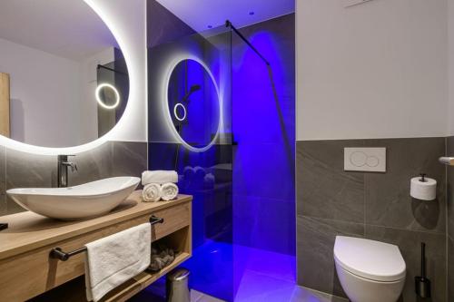 a bathroom with a sink and a toilet and a mirror at Hotel Hubertushof in Grossarl