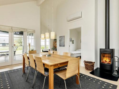 a dining room with a table and a fireplace at 4 star holiday home in Nysted in Nysted