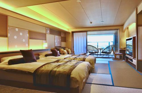 a room with a row of beds in a room at Sun Urashima Yuki no Sato in Toba