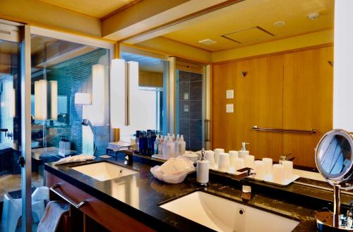 a bathroom with two sinks and a large mirror at Sun Urashima Yuki no Sato in Toba