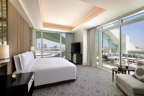a bedroom with a large white bed and a living room at Sofitel Riyadh Hotel & Convention Centre in Riyadh