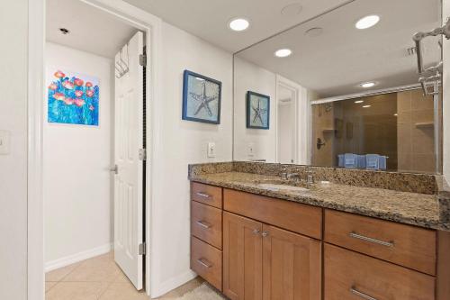 Un baño con lavabo y un espejo grande. en Minorca The Inlet 903, en New Smyrna Beach