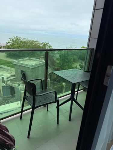 a balcony with a table and a chair and the ocean at DreamSide Apartment by Ili - Next to Dreamland Oasis, Chakvi in Chakvi