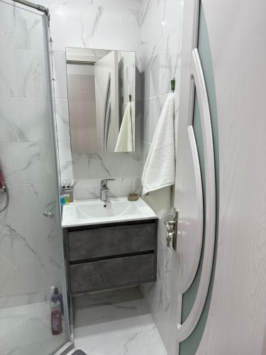a white bathroom with a sink and a shower at DreamSide Apartment by Ili - Next to Dreamland Oasis, Chakvi in Chakvi