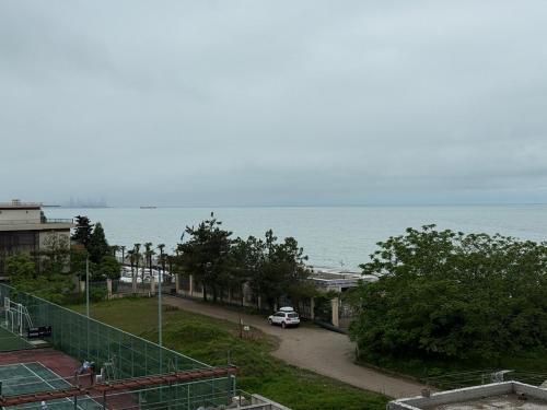 a car driving down a road next to the ocean at DreamSide Apartment by Ili - Next to Dreamland Oasis, Chakvi in Chakvi