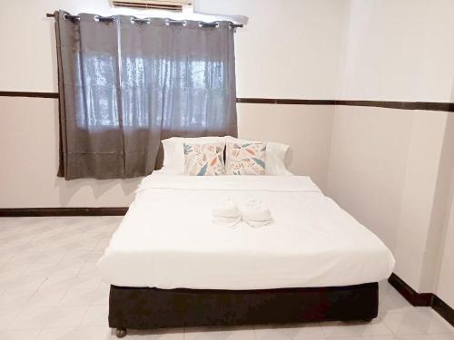 a bedroom with a bed with two shoes on it at XX Mitr Inn Phuket Oldtown - มิตรอินน์ ภูเก็ต โอลทาวน์ in Phuket