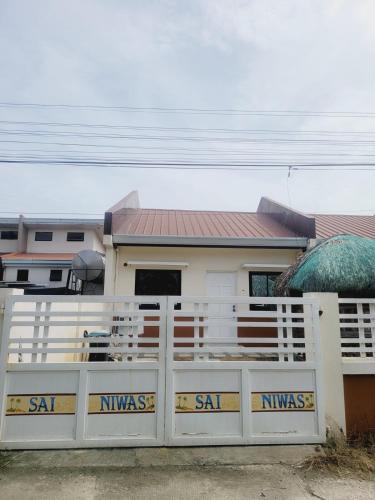 a white fence in front of a house at Ilocos Norte Staycation in Laoag in Laoag