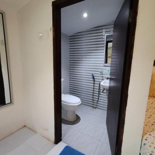 a bathroom with a toilet and a sink at Fikri Wetland Guesthouse & Resort in Kampung Kuala Setiu Lama