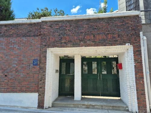 a brick building with two green doors at Sun Gangnam Stay in Seoul