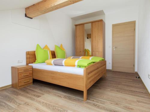 a bedroom with a bed with green and orange pillows at Traumhaftes Feriendomizil für Familien in Ellscheid
