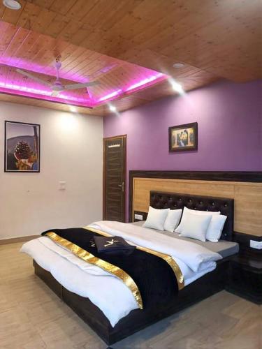 a bedroom with a large bed with a purple wall at Exotic Stays I Pine Group Of Hotels & Villas Kasauli in Kasauli