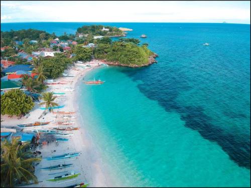 an aerial view of a beach with boats in the water at Malapasqua Island Cottage Holiday House in Daanbantayan