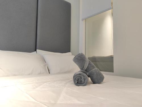 a stuffed teddy bear sitting on a bed at Vetro11 Beside QEH1 by JUNE Homestay in Kota Kinabalu