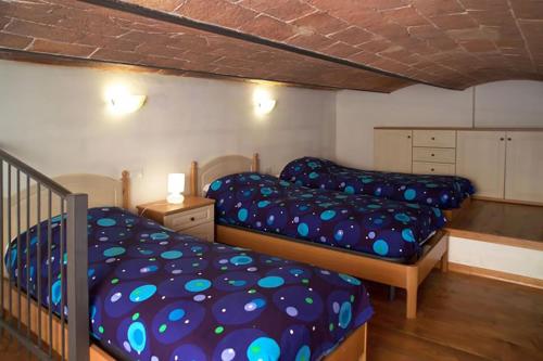 a bedroom with two beds and a staircase at Agriturismo Fattoria Loppiano 4-0 in Incisa in Valdarno