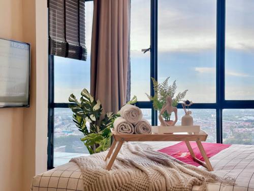 a bed with a table in front of a window at Alviv 99 Suites I Family Suite I 4-7 pax I 5minsMelakaCruise I JonkerSt in Melaka