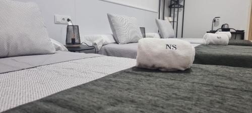 a bedroom with three beds with a nss pillow on the bed at NS Bolaños in Bolaños de Calatrava