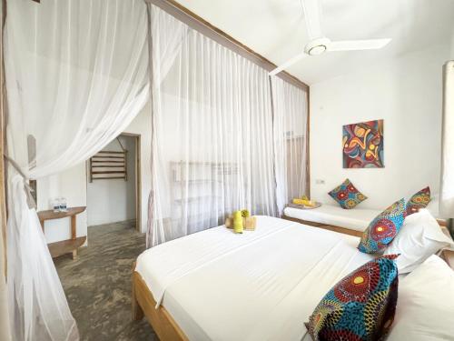 a bedroom with a bed with a teddy bear on it at BONDENI BEACH HOUSE in Jambiani