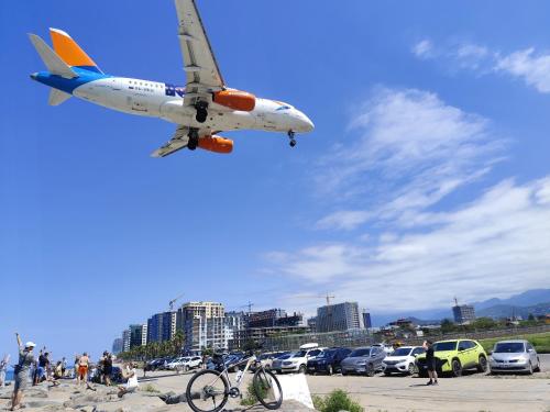 an airplane is flying over a parking lot with cars at Aqua Batumi 84 in Batumi