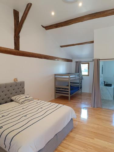 a bedroom with a large bed and a bathroom at Ranch du pont urgin in Planrupt