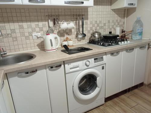 a kitchen with a washing machine and a sink at Soft House in Mykolaiv