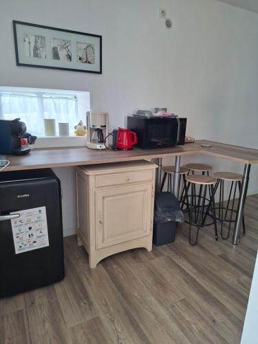 a kitchen with a counter and a table and chairs at La mission in Saint-Martin-des-Noyers