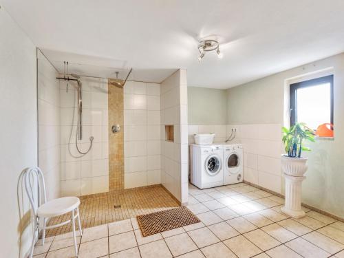a bathroom with a shower and a washing machine at Holiday home Eifelhome in Germany in Kleinlangenfeld