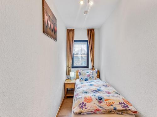 a small bedroom with a bed and a window at Holiday home Eifelhome in Germany in Kleinlangenfeld