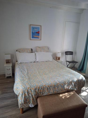 a bedroom with a large bed and a chair at La mission in Saint-Martin-des-Noyers