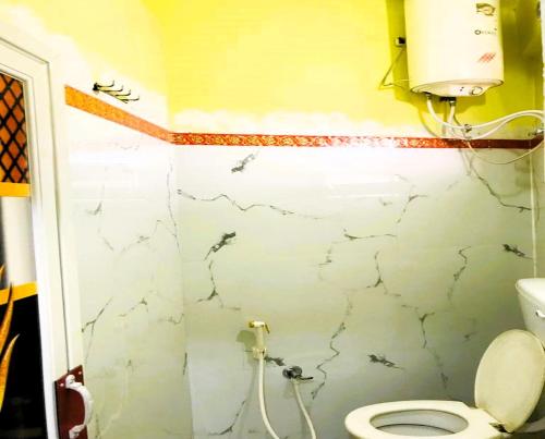 a small bathroom with a toilet and a shower at Jagannath International Hotel near Kolkata Airport in kolkata