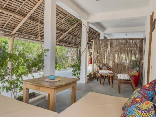 a living room with a table and chairs at BONDENI BEACH HOUSE in Jambiani