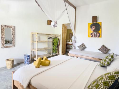 two beds in a room with white walls at BONDENI BEACH HOUSE in Jambiani