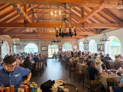 a group of people sitting at tables in a restaurant at Mountain View RESORT in Vusanje