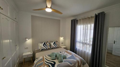 Un dormitorio con una cama con ventilador de techo. en Apartamento Playa Gran Tarajal, en Gran Tarajal