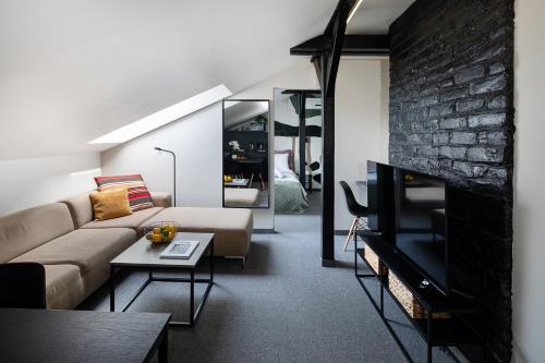a living room with a couch and a brick wall at RixStay Apartments in Rīga