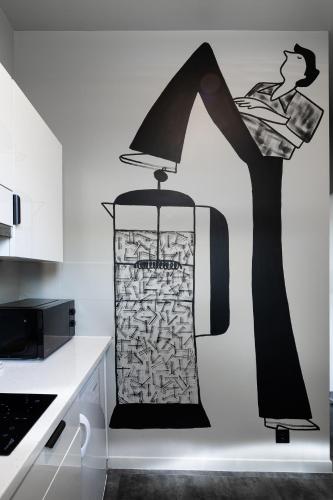 a lamp with a woman on a wall in a kitchen at RixStay Apartments in Rīga