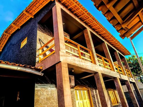 una casa con fachada azul con ventanas amarillas en PANORÂMIC LUXO EXCLUSIVe, en Santa Cruz Cabrália