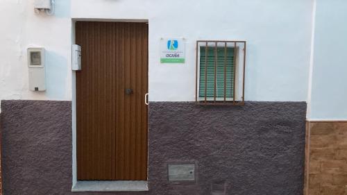 una porta marrone sul lato di un edificio di Casa rural ocaña a La Puebla de los Infantes