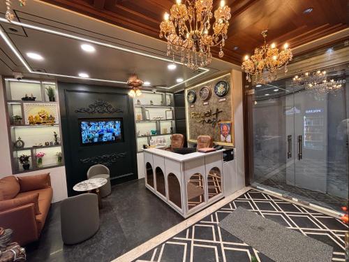 a room with a bar with a tv and chandeliers at Hotel Royal Nest in Ajmer