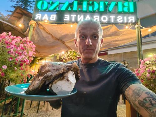 a man holding a plate with a rock on it at Locanda di Bivigliano in Bivigliano