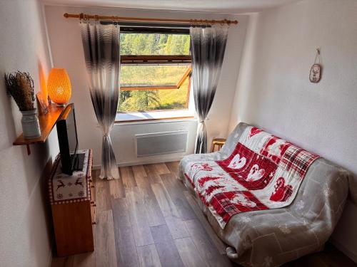 a living room with a couch and a window at La Foux d Allos Studio résidence Les Étoiles in Allos