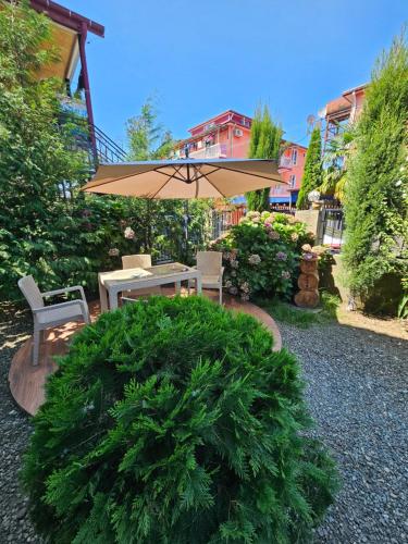 eine Terrasse mit Tisch und Sonnenschirm in der Unterkunft Guesthouse Maka in Ureki