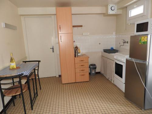 a small kitchen with a table and a refrigerator at Appartement Erable-Résidence Les Glycines in Eugénie-les-Bains