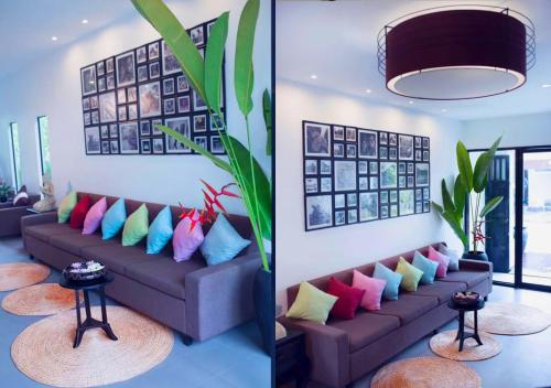 a living room with a couch with colorful pillows at Angkor Land House in Phumĭ Réach Born