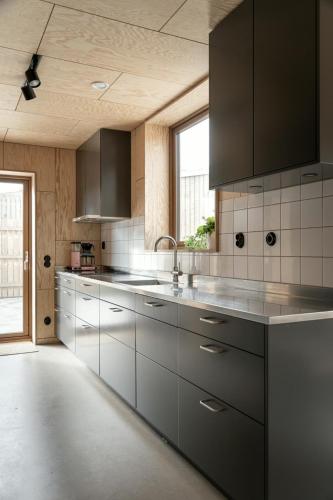 a kitchen with stainless steel appliances and a window at Kivikshusen in Kivik